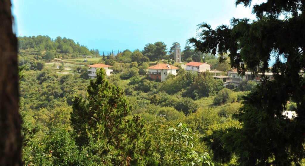 Θέα από ψιλά στον πέτρινο πύργο με ρολόι της Αιγάνης
