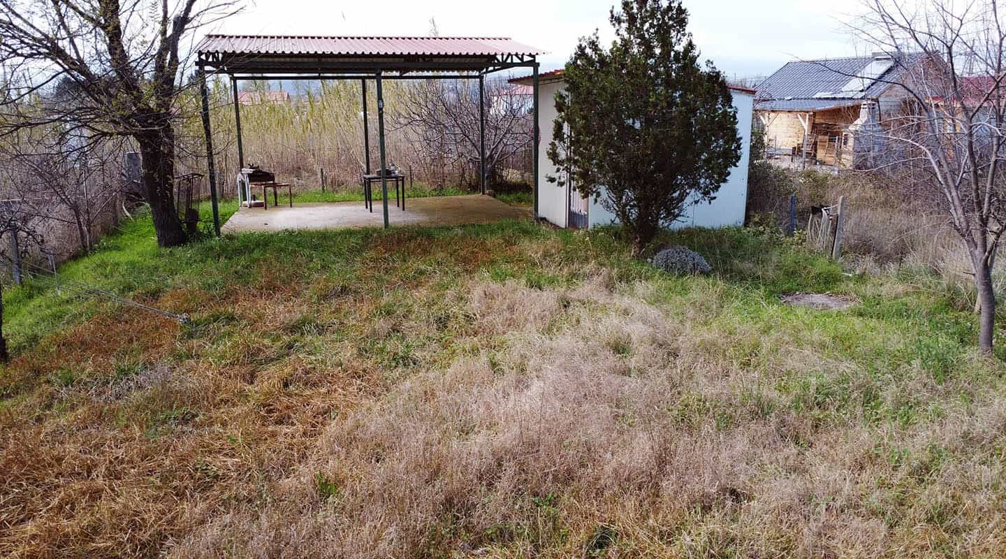 Καστρί Λουτρό Αγροτεμάχιο με πάνελ από πλάι με κιόσκι και σπίτι, γειτονιά και δέντρα από κοντά-Προβατίδης μεσιτικά
