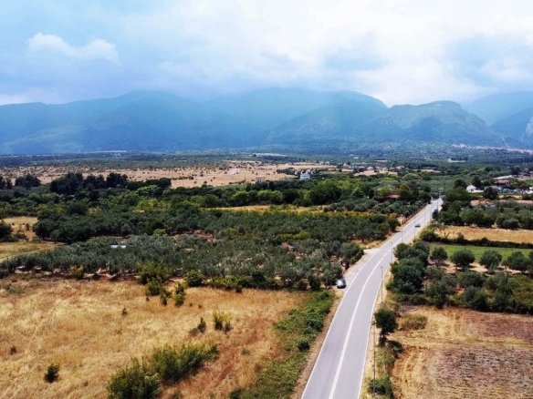 Προβατίδης μεσιτικά Πλάκα Λιτοχώρου θέα από ψηλά από στο αγροτεμάχιο με φόντο τον δρόμο και τους συνεφιασμένους πρόποδες Ολύμπου