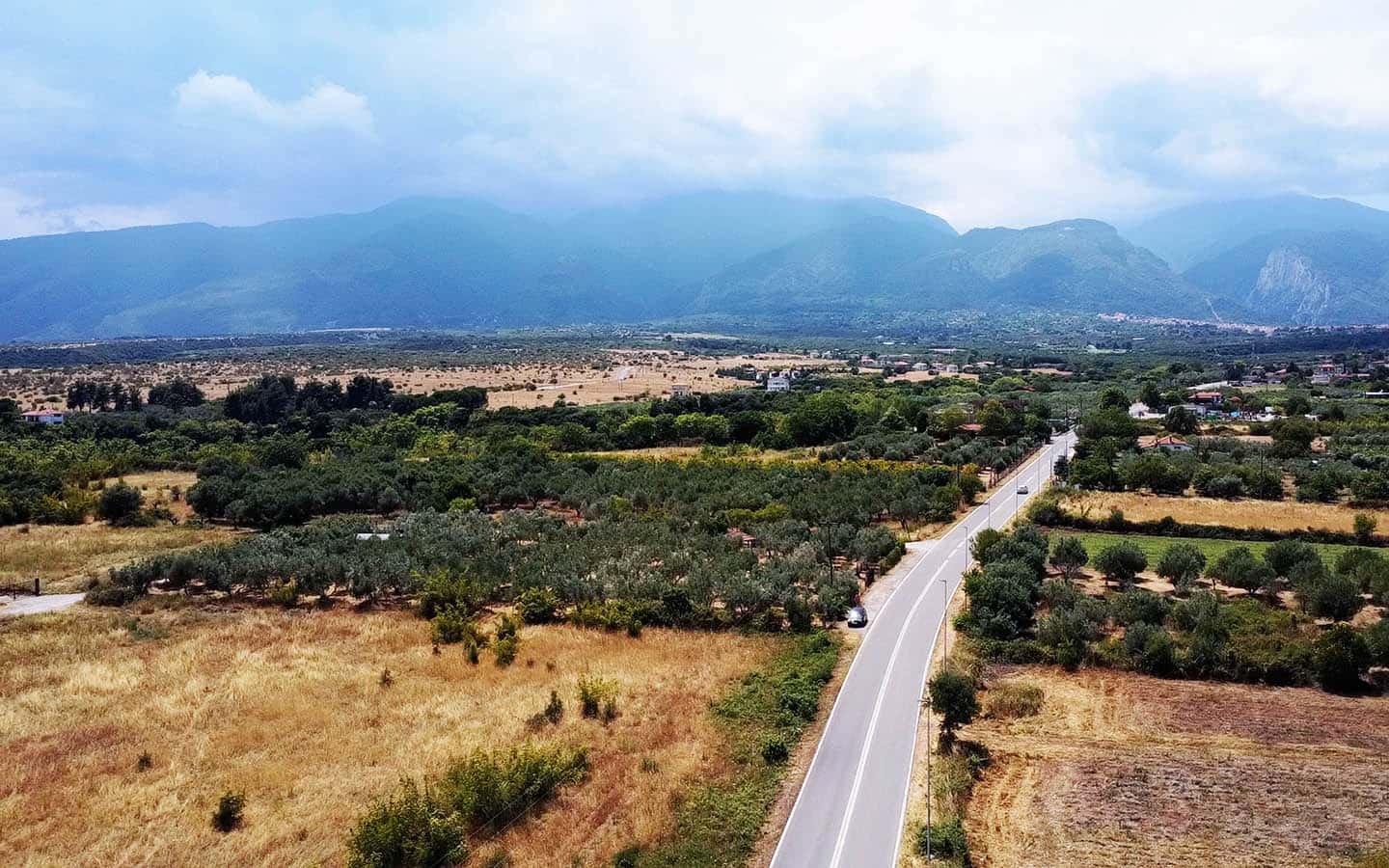 Προβατίδης μεσιτικά Πλάκα Λιτοχώρου θέα από ψηλά από στο αγροτεμάχιο με φόντο τον δρόμο και τους συνεφιασμένους πρόποδες Ολύμπου